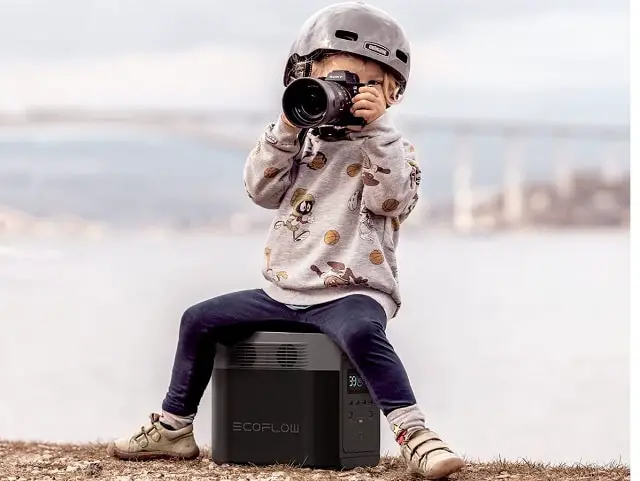 Jeune garçon assis sur un générateur ecoflow solide